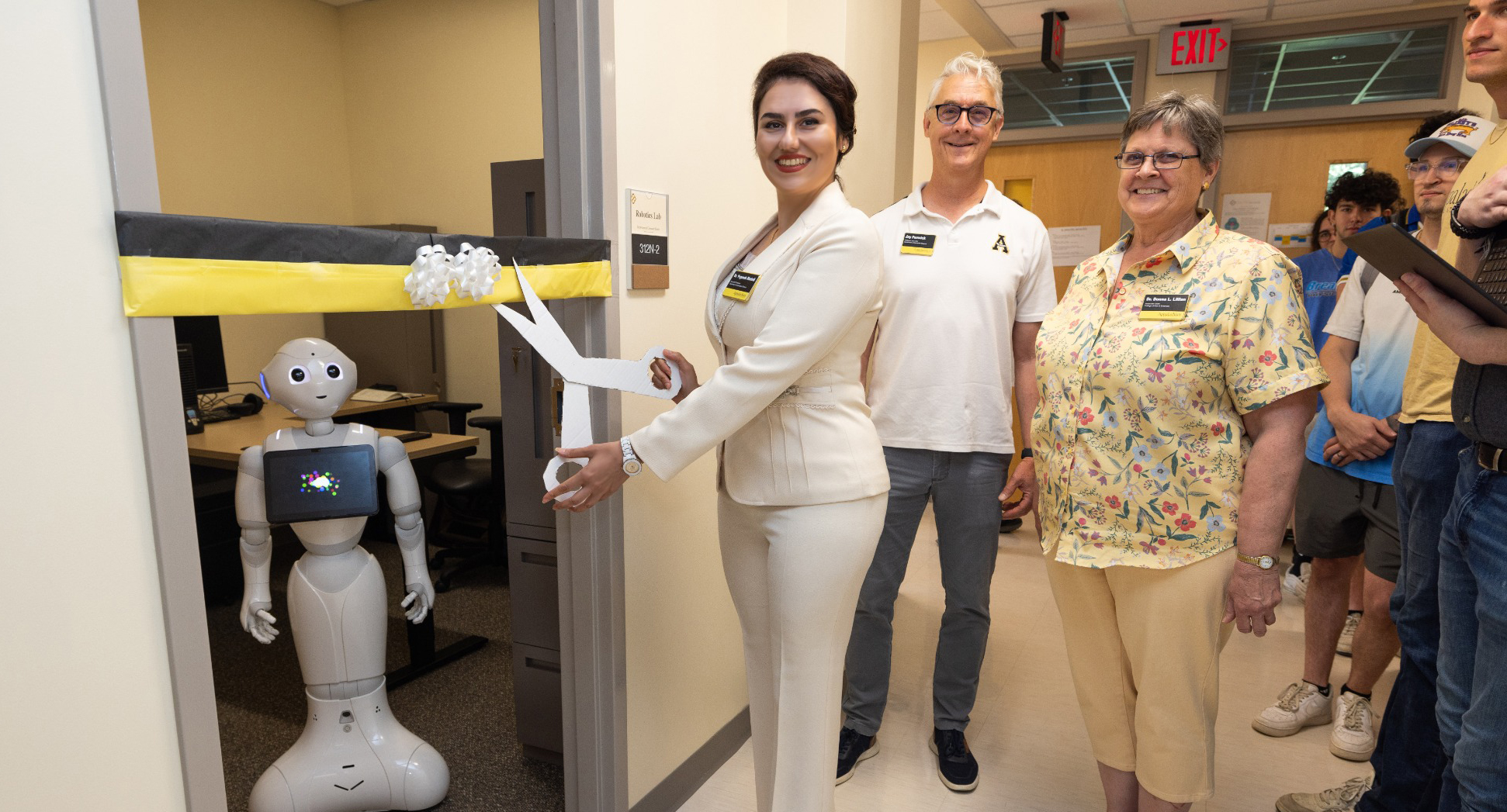 Ribbon cutting ceremony with humanoid robot and faculty